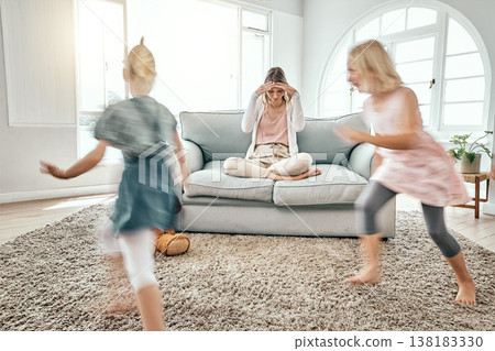 Mother, children and running in living room chaos with headache in stress on sofa at crazy or busy home. Frustrated single parent in burnout with ADHD or hyperactive kids or siblings playing in house 138183330
