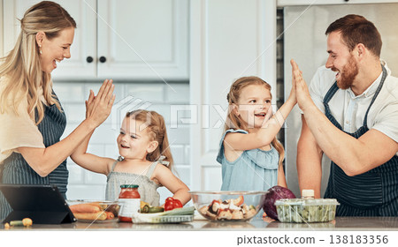 Happy family in kitchen, cooking with kids and high five with success, learning and nutrition with parents. Mom, dad and girl children making healthy food in home with care, celebration and lunch. Happy family in kitchen, cooking with kids and high five with success, learning and nutrition with parents. Mom, dad and girl children making healthy food in home with care, celebration and lunch. 138183356