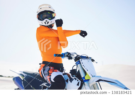Motorbike, arm stretch and ready for race in desert, training and practice for challenge on sand dunes. Athlete, fast and adrenaline in extreme sports, fitness and energy for competition on dirt bike Motorbike, arm stretch and ready for race in desert, training and practice for challenge on sand dunes. Athlete, fast and adrenaline in extreme sports, fitness and energy for competition on dirt bike 138183421
