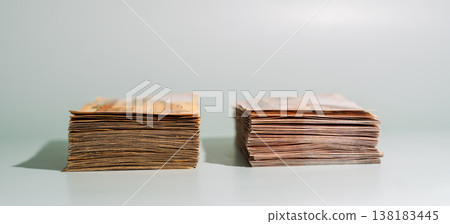 Two bundles of 1000 Kazakhstani tenge banknotes with different designs side by side on green background, comparison concept Two bundles of 1000 Kazakhstani tenge banknotes with different designs side by side on green background, comparison concept 138183445
