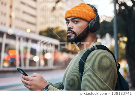 Smartphone, headphones of student and thinking in city, listening to music or sound. Phone, radio and serious man in street for streaming podcast, typing on social media and hearing audio to travel 138183741