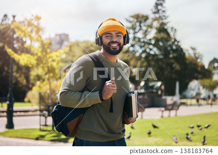 Portrait of happy man on campus with books, headphones and backpack on morning commute for education. Learning, studying and college student in park with podcast, music or streaming online on walk. Portrait of happy man on campus with books, headphones and backpack on morning commute for education. Learning, studying and college student in park with podcast, music or streaming online on walk. 138183764