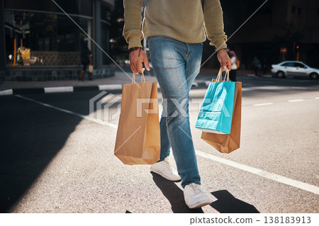 Man, legs and shopping bags in street of city, pedestrian or crosswalk for travel, shop or mall. Male person or shopper walking on road with paper bag for discount, sale or retail store in urban town 138183913