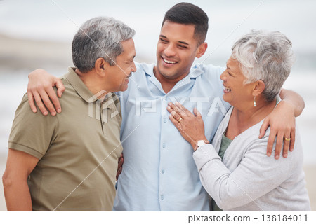 Man, senior parents or laughing at beach for bond, support or love with smile, care or pride in retirement. Hug, father or mature mother with a happy son at sea together on family holiday vacation 138184011