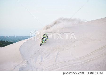 Motorcycle, desert and race for sports in sand, adrenaline and training for fitness in competition. Athlete, sky and mockup for extreme sport, driving and dirtbike in outdoor for stunt or performance 138184161