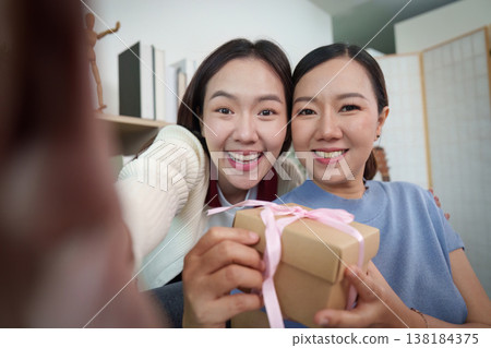 Mother and daughter exchanging a gift with joy Mother and daughter exchanging a gift with joy 138184375