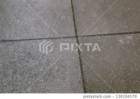Speckled Grey Rubber Gym Floor Tiles with Interlocking Seams Close Up Speckled Grey Rubber Gym Floor Tiles with Interlocking Seams Close Up 138184579