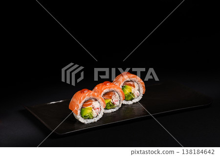 Delicious Fresh Salmon Sushi Rolls Presenting Exquisitely on a Black Background Delicious Fresh Salmon Sushi Rolls Presenting Exquisitely on a Black Background 138184642