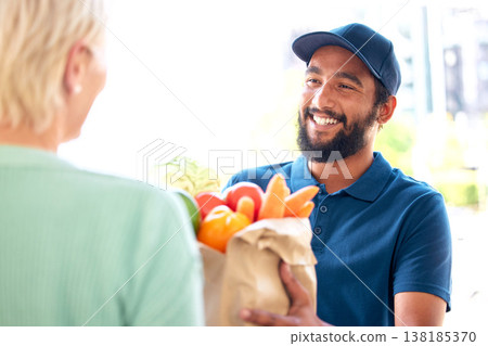 Delivery man, groceries and smile for customer, food and fresh produce from online shopping. Happy person, supermarket discount and deal from supply chain, distribution with front door service. 138185370