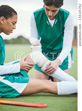 Sports, knee pain or woman with a bandage on field or turf struggling with first aid in game or match. Emergency, bad injury or hockey athlete on artificial grass with medical help from an accident Sports, knee pain or woman with a bandage on field or turf struggling with first aid in game or match. Emergency, bad injury or hockey athlete on artificial grass with medical help from an accident 138185762