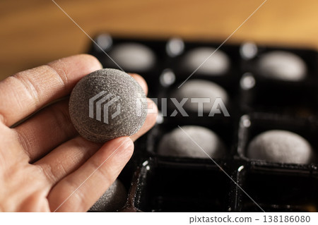 Artisan carefully inspecting sugarcoated chocolate piece during small batch production process 138186080