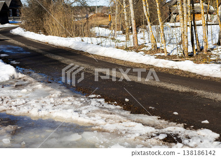 Winter melts away. Peaceful rural scene as snow thaws amidst muddy roadside surroundings Winter melts away. Peaceful rural scene as snow thaws amidst muddy roadside surroundings 138186142