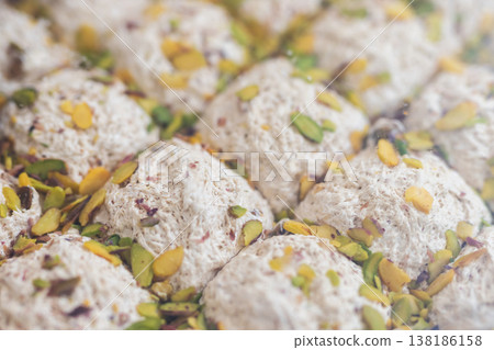 Sophisticated photograph of coconut sweets adorned with pistachios and powdered sugar Sophisticated photograph of coconut sweets adorned with pistachios and powdered sugar 138186158