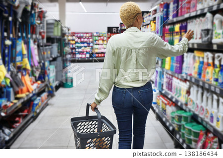Back, shopping in a grocery store and a woman customer looking to purchase a product for retail spending. Supermarket, shelf or choice of food with a consumer or shopper carrying a basket in an aisle Back, shopping in a grocery store and a woman customer looking to purchase a product for retail spending. Supermarket, shelf or choice of food with a consumer or shopper carrying a basket in an aisle 138186434