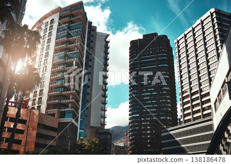 City, buildings and development with landscape for urban infrastructure or architecture outdoor. Skyscraper, town and skyline with cityscape, tower and hotel facade with modern exterior and sky 138186478