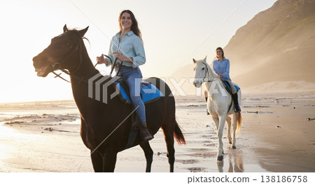 Woman, happy and horse riding with face at beach for bond, activity or self care on holiday. Female, friends or people on vacation by travel for relaxing, health or love at shore, mountains and sport Woman, happy and horse riding with face at beach for bond, activity or self care on holiday. Female, friends or people on vacation by travel for relaxing, health or love at shore, mountains and sport 138186758