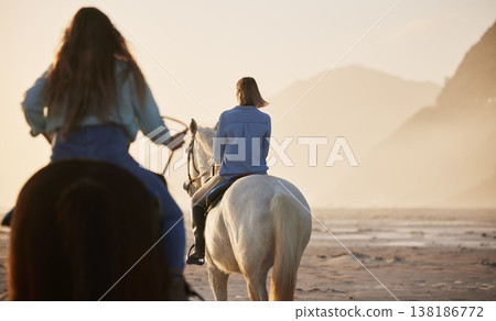 Woman, horse riding and activity at beach, together and back view for exercise, wellness or health. Female, person or friends with workout on vacation, holiday and traveling at sunset for self care Woman, horse riding and activity at beach, together and back view for exercise, wellness or health. Female, person or friends with workout on vacation, holiday and traveling at sunset for self care 138186772