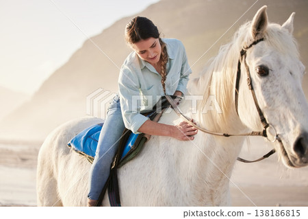 Beach, equestrian and woman riding her horse outdoor on a summer morning for training or practice. Nature, sunset and a young rider on horseback with her pet animal by the ocean or sea to relax Beach, equestrian and woman riding her horse outdoor on a summer morning for training or practice. Nature, sunset and a young rider on horseback with her pet animal by the ocean or sea to relax 138186815