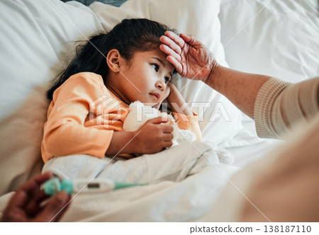 Girl child, check for fever and sick in bed with thermometer, health and wellness, parent monitor temperature at home. Headache, illness and young kid with the flu, medical help and support in bed Girl child, check for fever and sick in bed with thermometer, health and wellness, parent monitor temperature at home. Headache, illness and young kid with the flu, medical help and support in bed 138187110