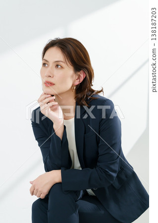 Portrait of a middle-aged woman wearing a navy jacket against a white background (vertical orientation). Portrait of a middle-aged woman wearing a navy jacket against a white background (vertical orientation). 138187203
