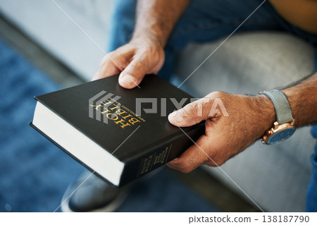 Bible, book and hands of man in home with study of Christian faith, religion or spirituality knowledge. Holy, worship and person with gospel, scripture or learning about God or story of Jesus Christ 138187790