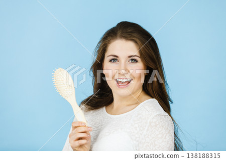 Happy woman brushing her hair Happy woman brushing her hair 138188315