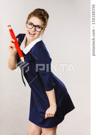 Teacher looking elegant woman holding big pencil Teacher looking elegant woman holding big pencil 138188356