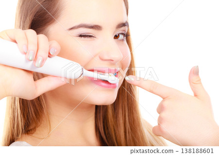 Woman smiling cleaning teeth with braces Woman smiling cleaning teeth with braces 138188601