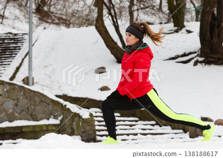 Woman exercising legs outside during winter Woman exercising legs outside during winter 138188617