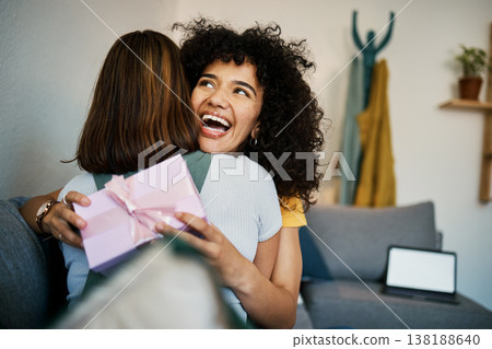 Excited, hug and present for birthday of girl friends and smile on living room sofa. Surprise, gift and happy female person at home with giving in lounge with celebration, congratulations and package Excited, hug and present for birthday of girl friends and smile on living room sofa. Surprise, gift and happy female person at home with giving in lounge with celebration, congratulations and package 138188640