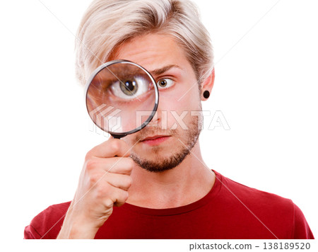 man holds on eye magnifying glass looking through loupe man holds on eye magnifying glass looking through loupe 138189520