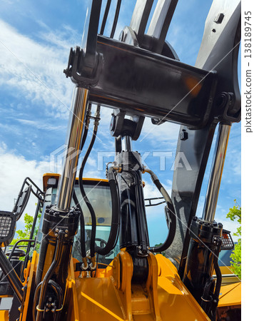Heavy equipment working on a construction site in a sunny location during the day with clouds in the sky 138189745