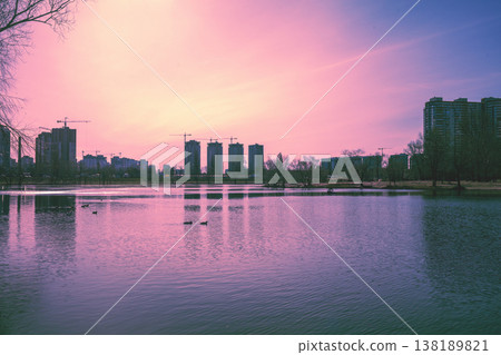 Skyline, Kyiv city in the evening. Left bank of the Dnieper River. Lake Telbin at sunset. Beautiful reflection of buildings in the lake 138189821