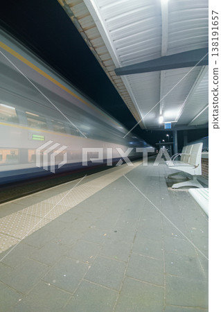 Night Train Passing Empty Platform at Urban Station With Motion Blur, Speed and Solitude Night Train Passing Empty Platform at Urban Station With Motion Blur, Speed and Solitude 138191657