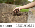 The image of farm work where soil is spilled from one's hands to improve the soil of a field. 138191681
