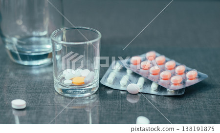 Close-up of Medical Tablets and Capsules in Small Glass with Blister Packs Close-up of Medical Tablets and Capsules in Small Glass with Blister Packs 138191875