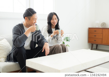 一對情侶坐在沙發上看著他們的智慧型手機 138192494