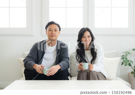 一對情侶坐在沙發上看著他們的智慧型手機 138192496