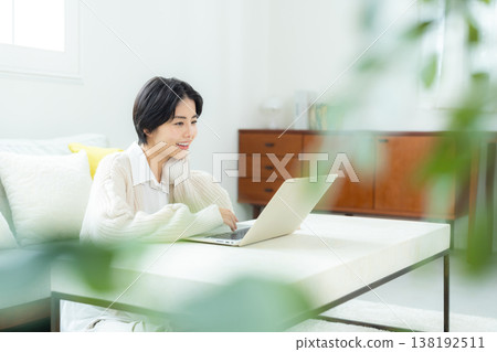 A woman watching a computer at home A woman watching a computer at home 138192511