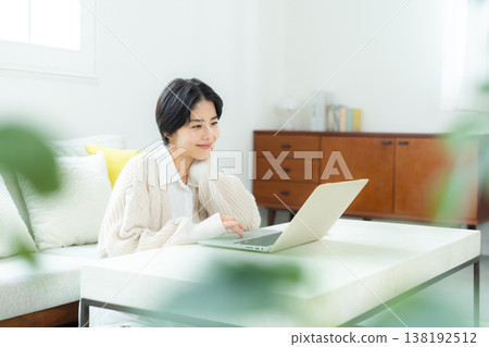 A woman watching a computer at home A woman watching a computer at home 138192512
