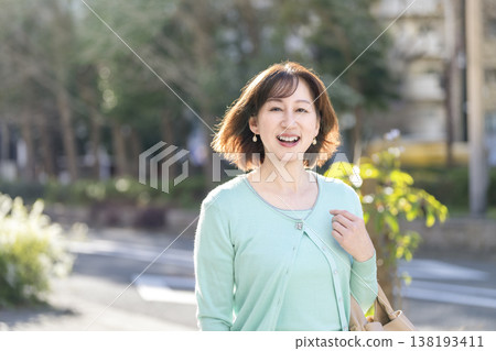 一位五十歲出頭的女士面帶微笑,直視鏡頭。 一位五十歲出頭的女士面帶微笑,直視鏡頭。 138193411