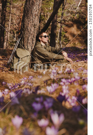 Man Hiker Sitting on Forest Clearing with Crocuses Man Hiker Sitting on Forest Clearing with Crocuses 138193784