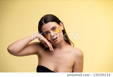Young woman applying eye patches for under eye skincare treatment, promoting beauty, health, and a luminous skin complexion with cosmetic care and hydration Young woman applying eye patches for under eye skincare treatment, promoting beauty, health, and a luminous skin complexion with cosmetic care and hydration 138194218
