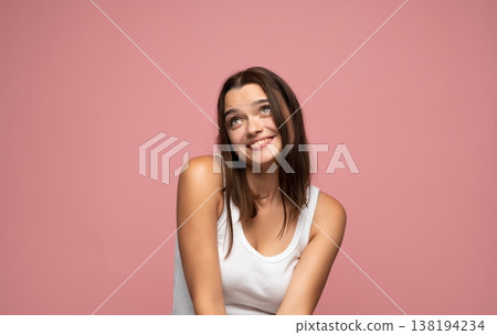 Young happy woman daydreaming and smiling, looking up with positive thoughts on pink background, feeling hopeful and thoughtful Young happy woman daydreaming and smiling, looking up with positive thoughts on pink background, feeling hopeful and thoughtful 138194234