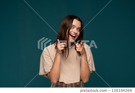 Young woman smiling, pointing fingers at camera, selecting or choosing you, expressing excitement and empowerment 138194269