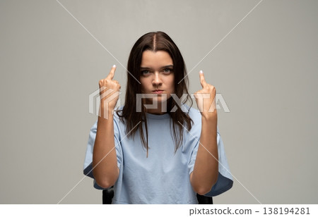 Young woman showing middle finger, expressing frustration, anger, and disrespect with rude hand gesture Young woman showing middle finger, expressing frustration, anger, and disrespect with rude hand gesture 138194281