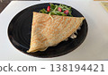 Chicken and mushroom cream crepe with salad on a black plate on a white table 138194421