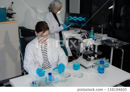 Medical Research Laboratory: Two scientists working, using digital tablets, analyzing samples, talking, developing biotechnology. Medical Research Laboratory: Two scientists working, using digital tablets, analyzing samples, talking, developing biotechnology. 138194605
