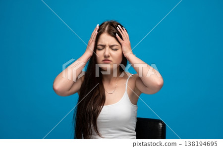 Young woman is having a headache, closing eyes and pressing hands to her head due to severe pain and migraine Young woman is having a headache, closing eyes and pressing hands to her head due to severe pain and migraine 138194695