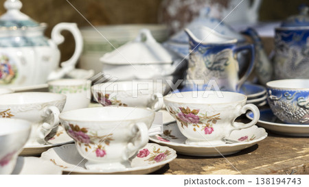 Vintage teacups and saucers with floral patterns arranged on a wooden table Vintage teacups and saucers with floral patterns arranged on a wooden table 138194743